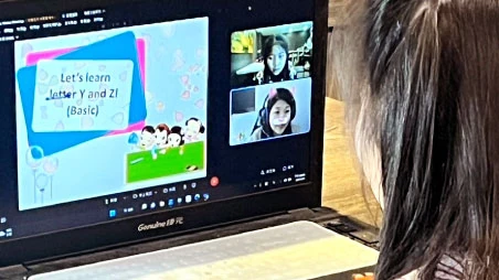 筆記型電腦螢幕上的英文教材與師生視訊畫面